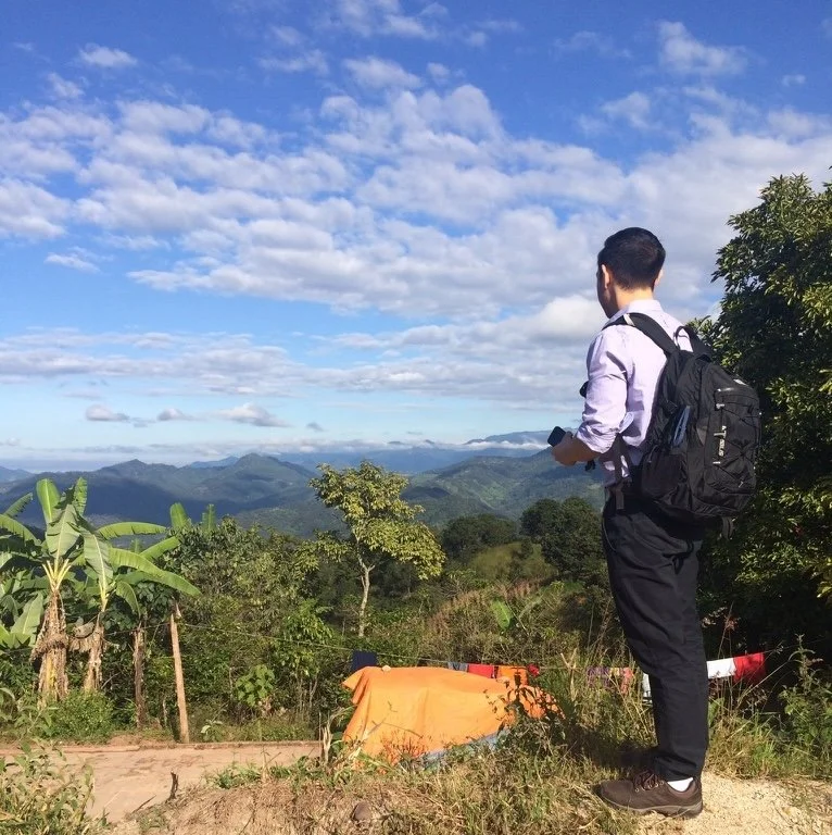 Shinichi Daimyo, psychiatric nurse practitioner and therapist serving greater Boston specializing in trauma, burnout, and life coaching, overlooking a rural valley