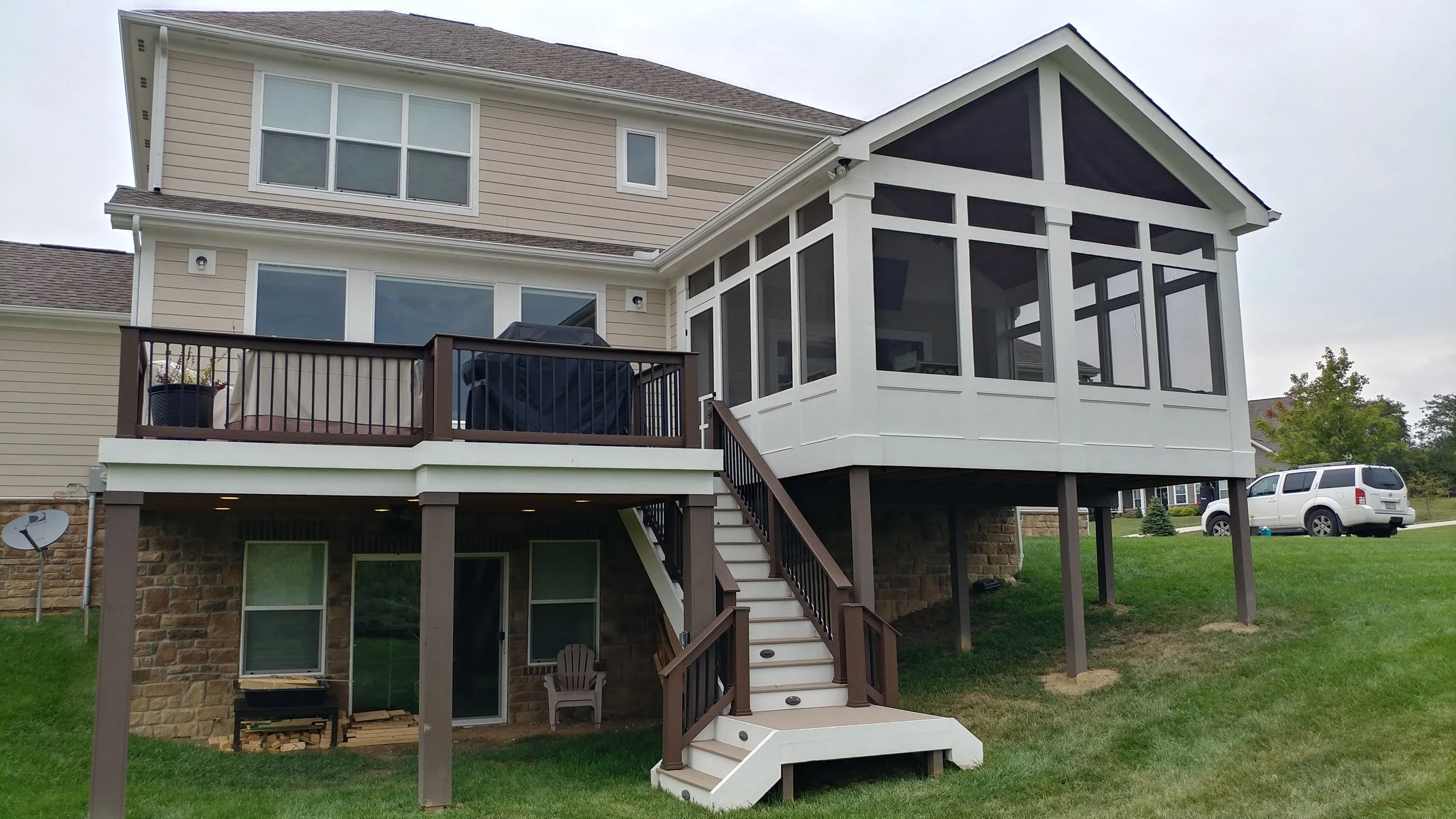 Back view of a two-story house with a raised deck and screened-in porch and a custom staircase built by Deck Masters in Dublin, Ohio.