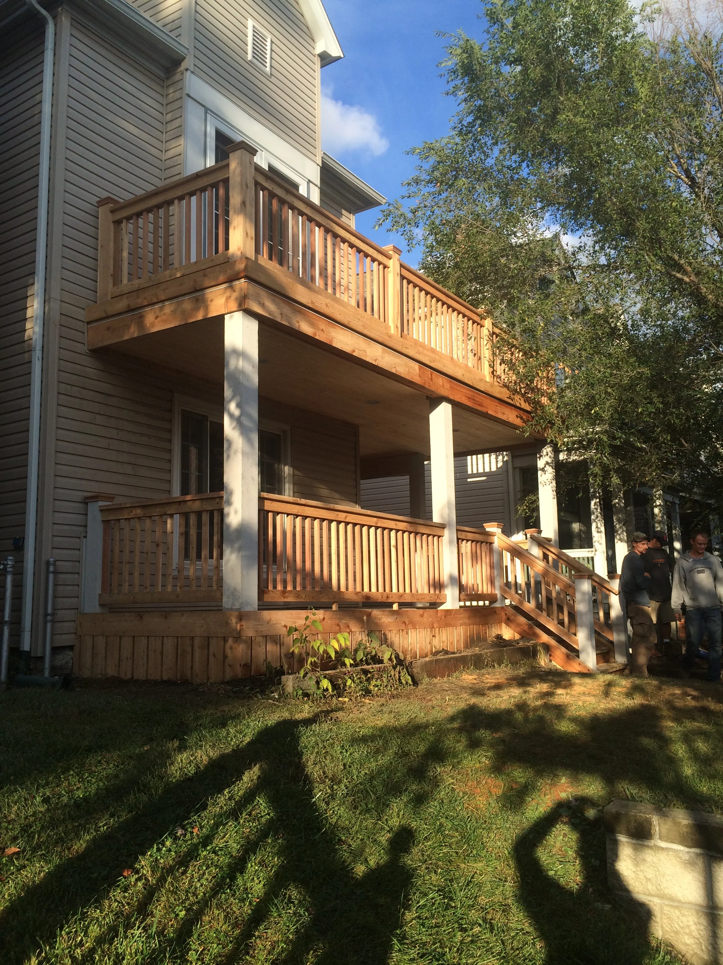 Two-story house with a newly built, custom wooden porch and balcony, crafted in Galena Ohio by Deck Masters.