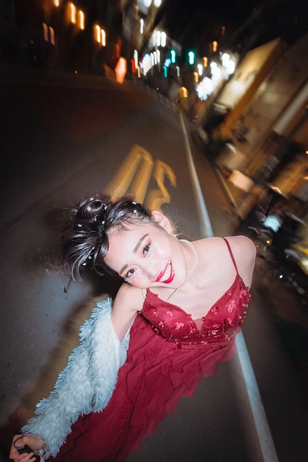 A Japanese girl in party dress on the streets of Tokyo Japan coming home from a party with a fun expression on her face