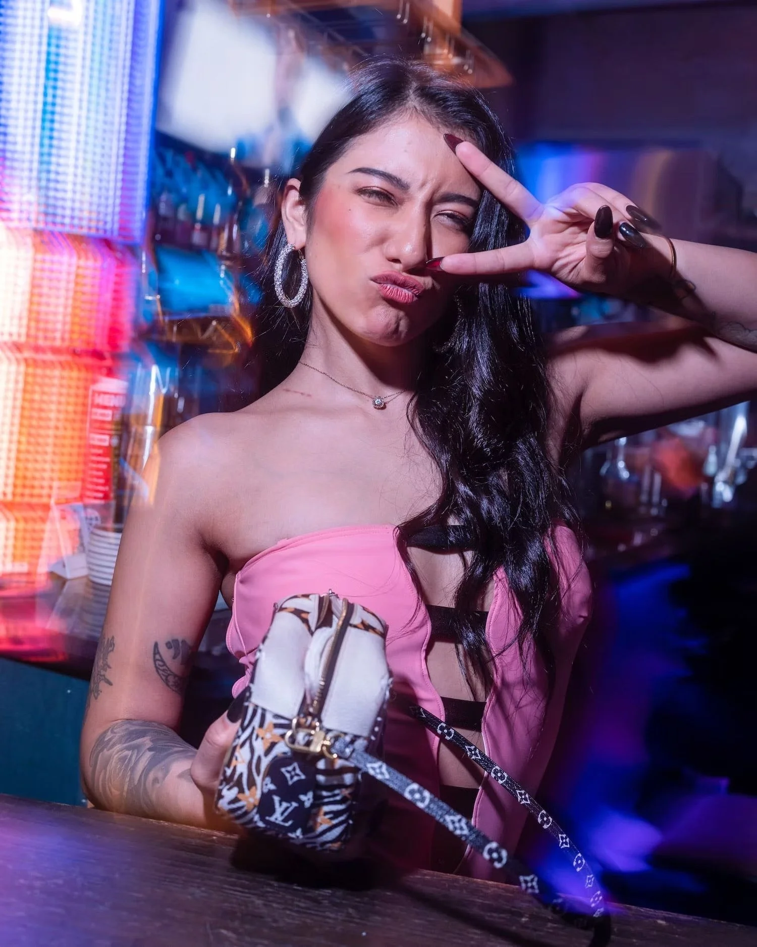 Stylish Woman Posing with Peace Sign at a Bar