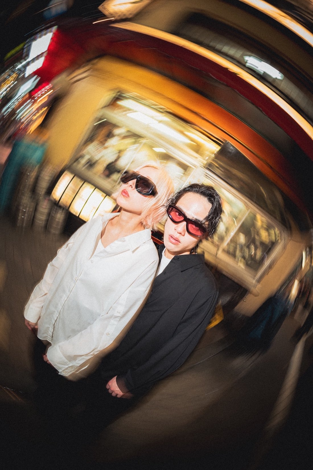 Vasuma Eyewear
---
Two individuals with sunglasses standing close together in a blurred indoor setting.