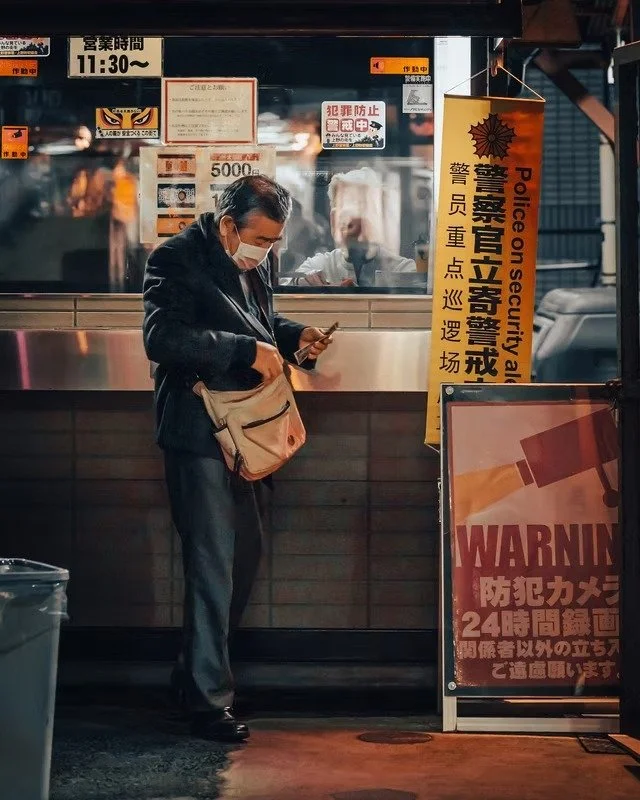 Man Stands Near Security Booth in Tokyo