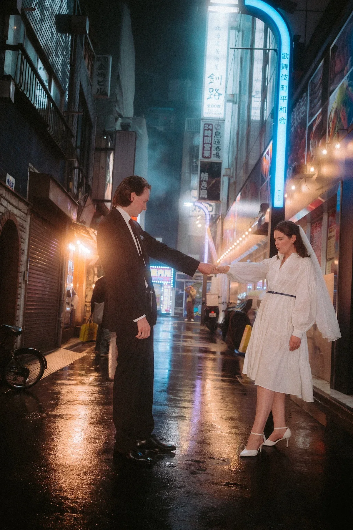  Couples portrait of newlywed walking under the warmly lit lanterns of a Shinjuku alleyway in Tokyo. 