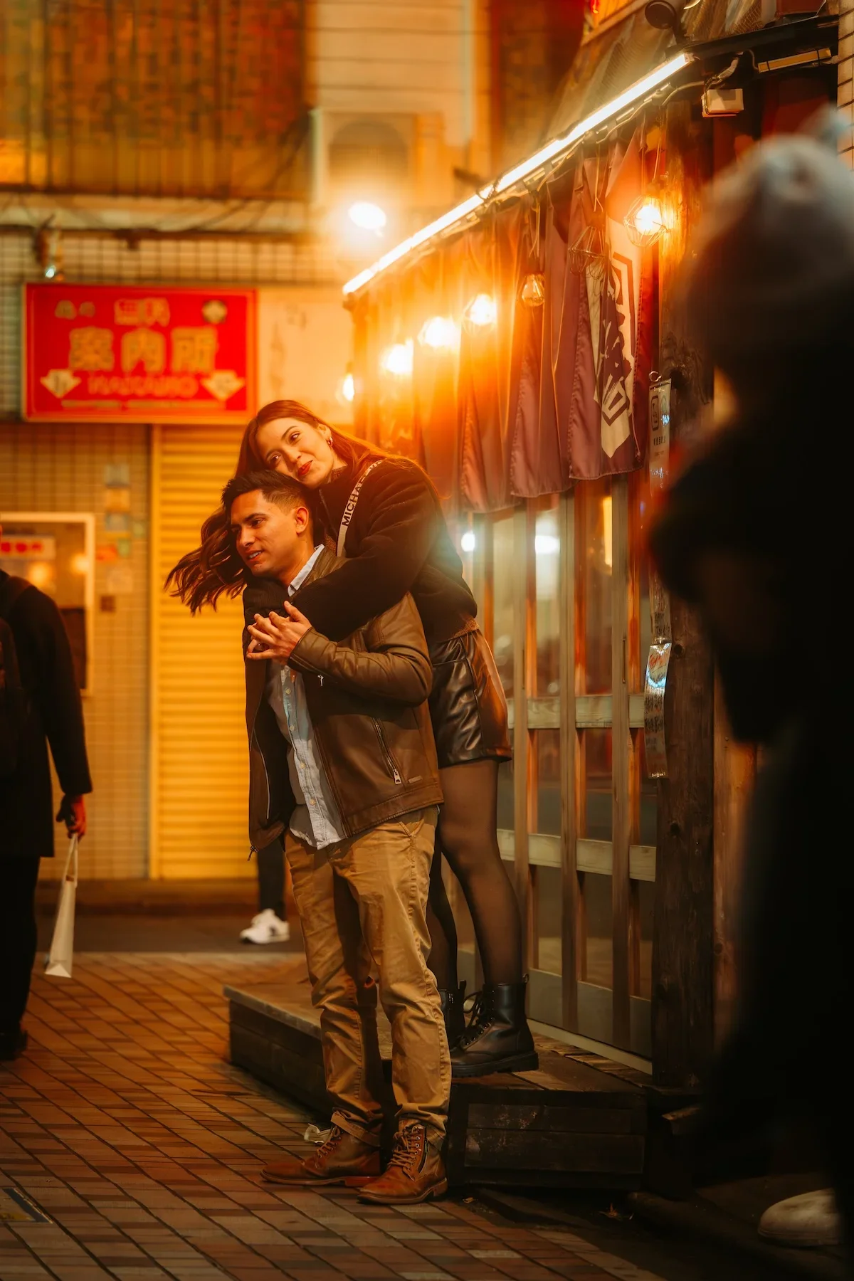  High-contrast portrait of a couple framed by the dense glowing neon canopies of Nakano's drinking alleys. 