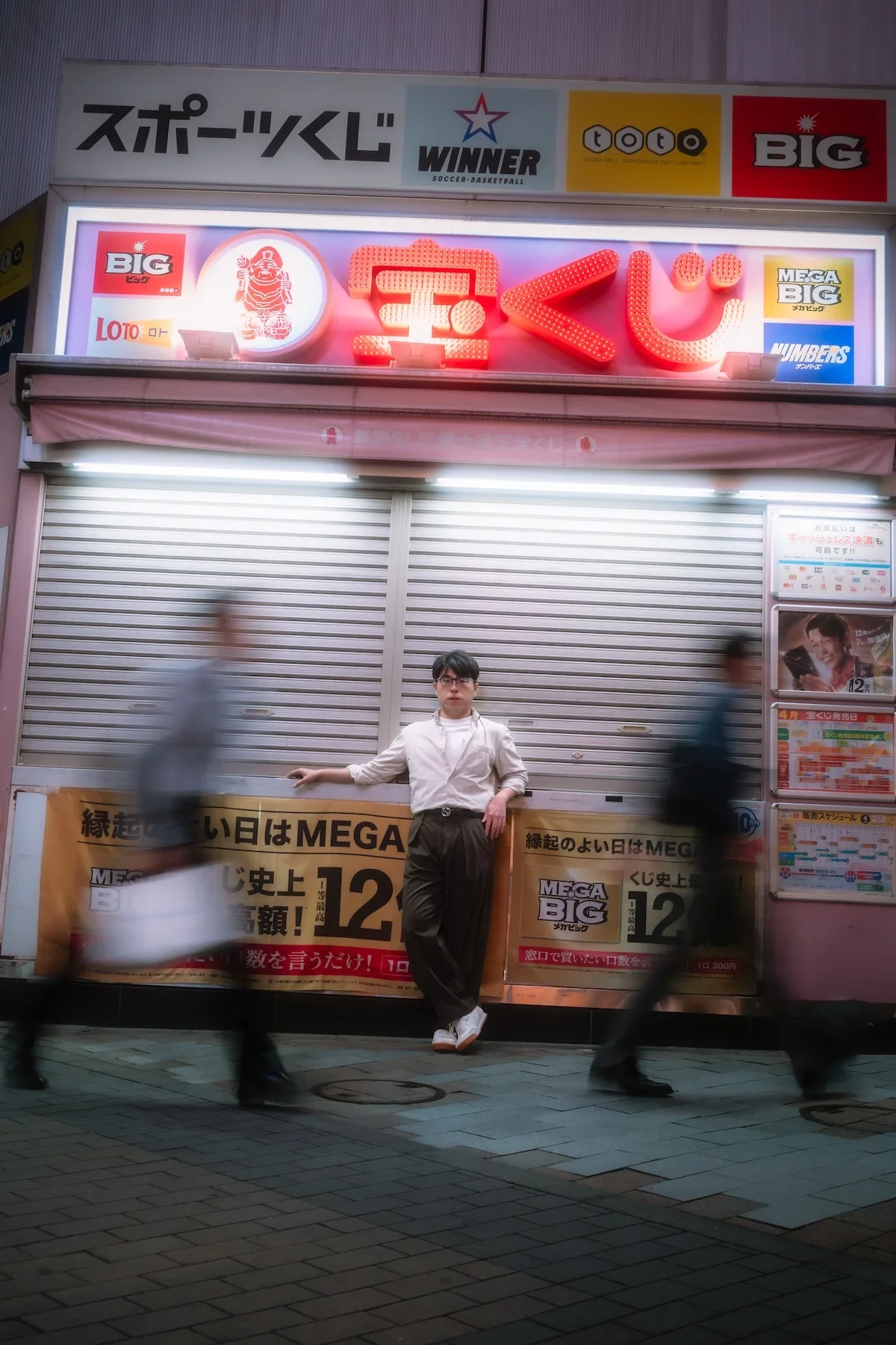  Moody street portrait defined by deep shadows and raw urban textures beneath the historic train tracks of Shimbashi. 