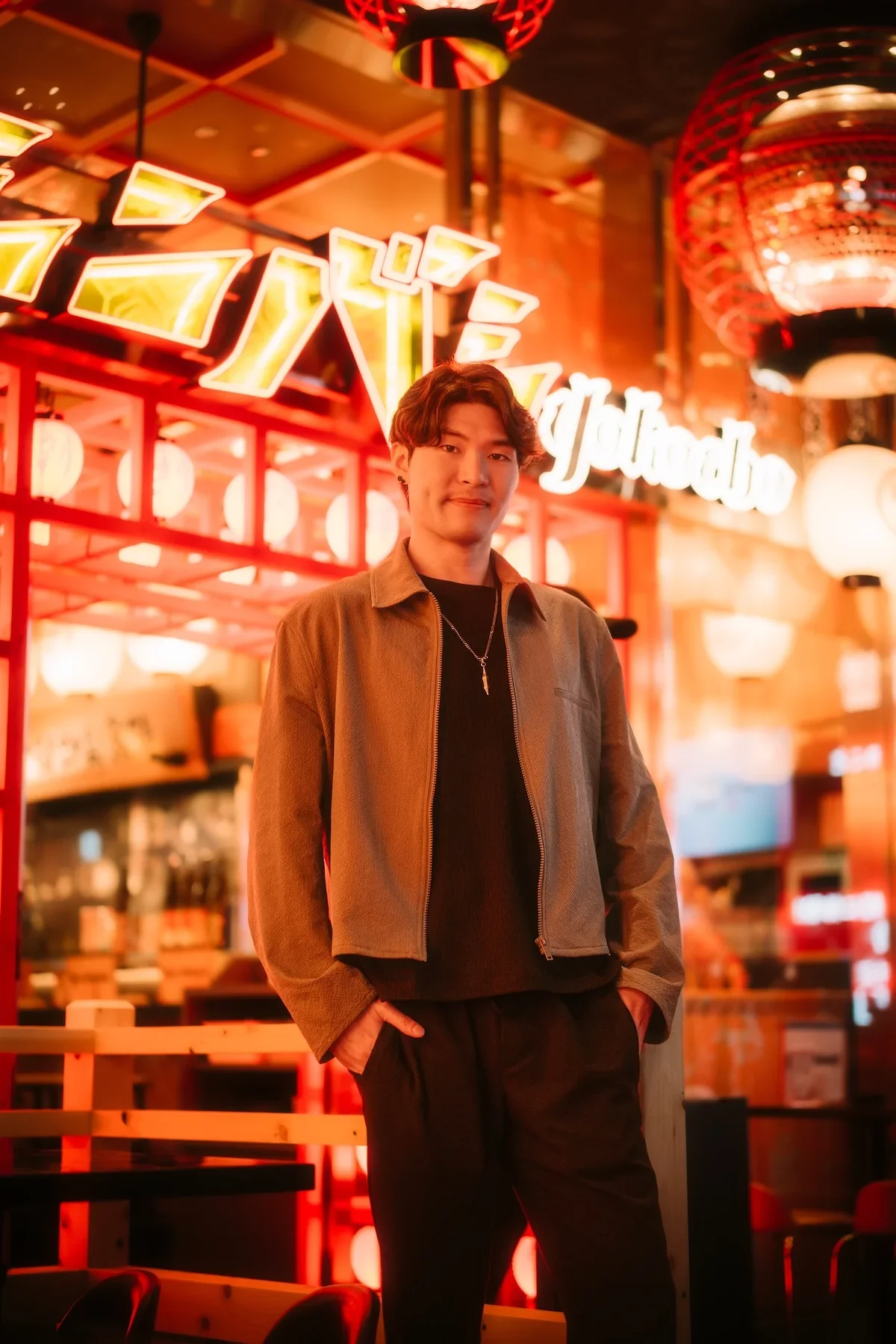  High-impact street portrait of a solo traveler capturing the energy of Tokyo salaryman nightlife under brick train arches. 