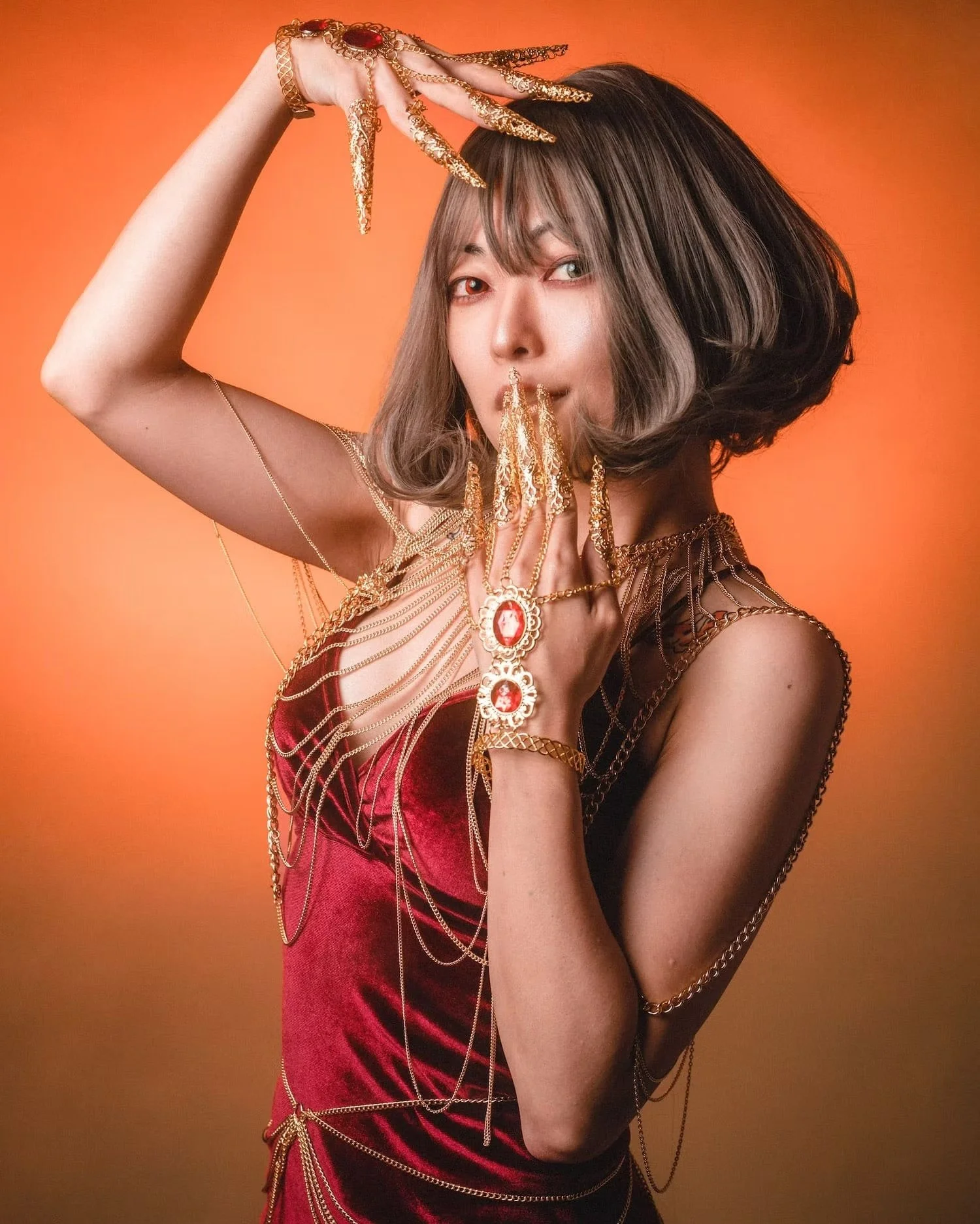 A woman in a striking red outfit gently pulls at her golden hair, giving a sensual and seductive look that blends elegance with drama.