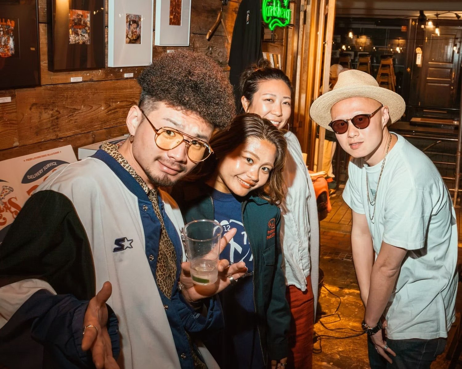 Group of friends posing at a party in Shibuya with drinks in hand.