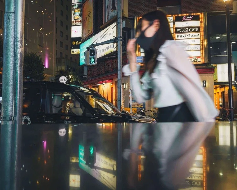 A person walking down a neon-lit street in Kabukicho, shot with an ultra-wide lens to include the vibrant surroundings.