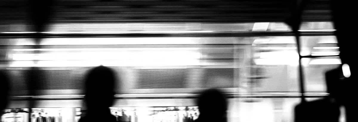A black and white blurred image of people in motion with a bold black box in the center displaying the word "PRINTS" in white capital letters.