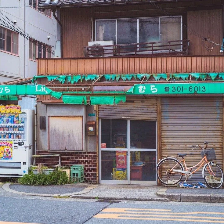 A small, quaint shop with a bicycle outside in Osaka, captured during slow travel through the city.