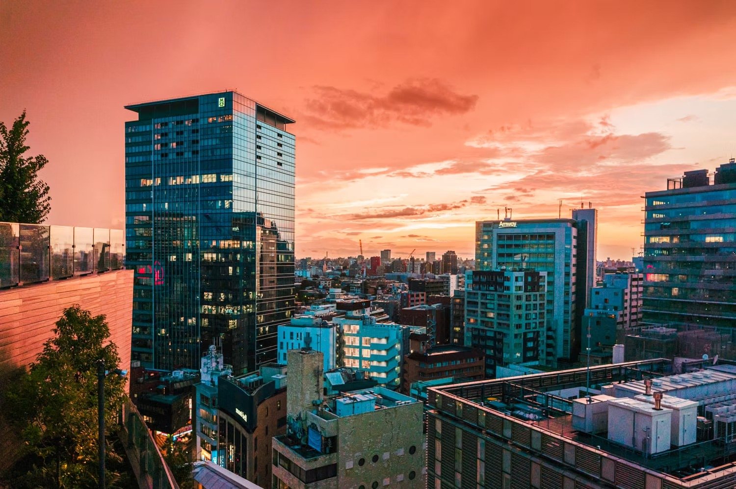 City skyline at sunset with tall modern buildings and colorful sky.