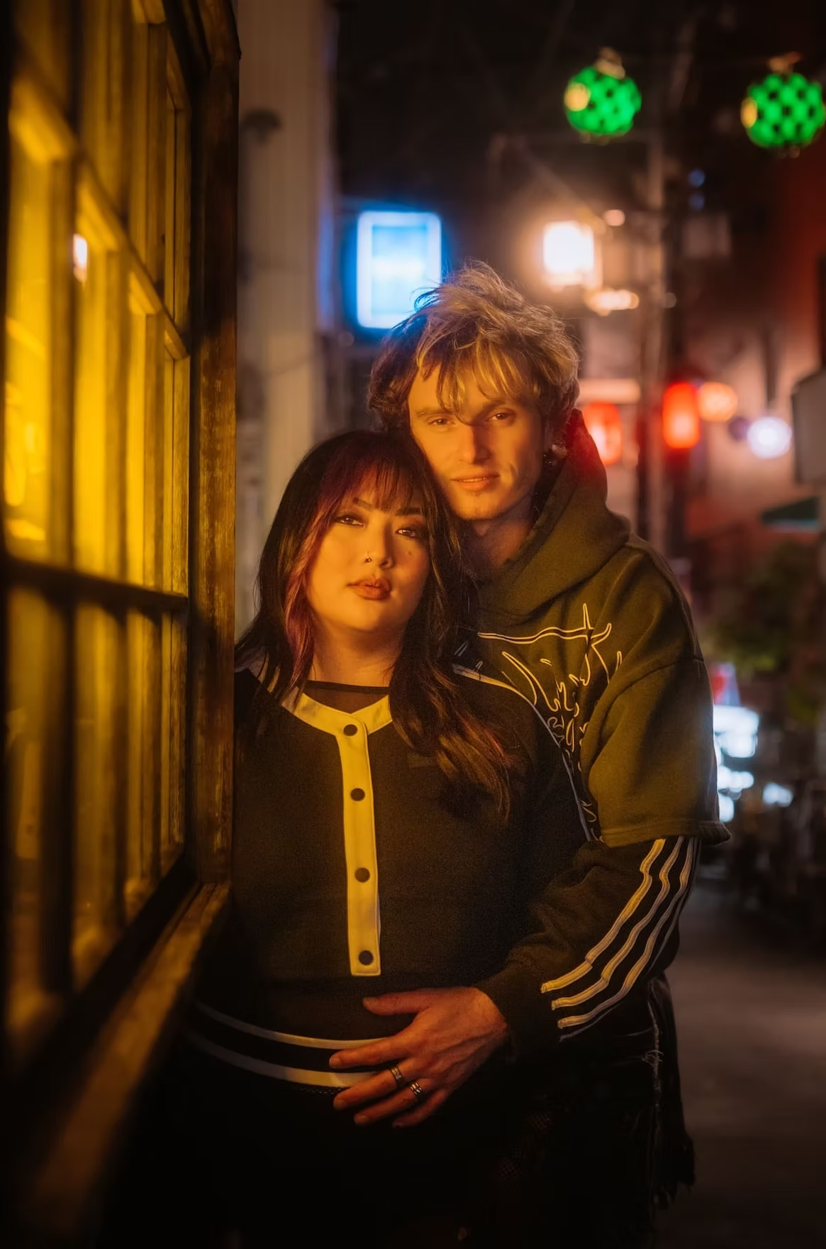 Couple wrapped in a glowing neon warm light in the streets of Nakano Tokyo holding each other romantically