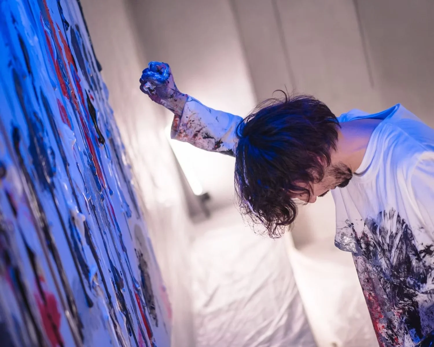 Artist with Raised Arm Amidst Abstract Art