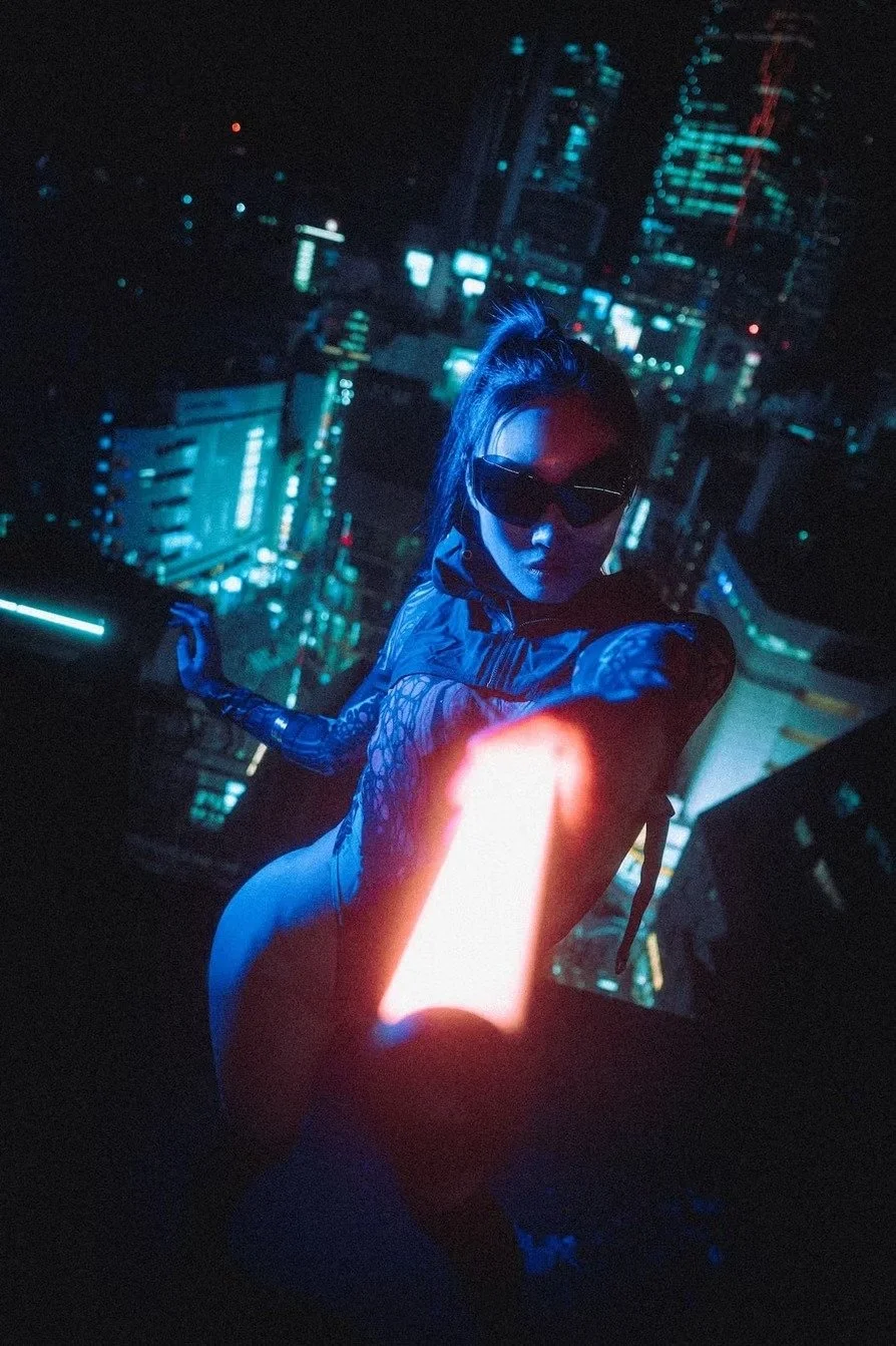 A cyberpunk portrait of a Japanese woman dressed in futuristic clothing and sunglasses standing in a neon-lit cityscape at night in Shibuya rooftop.