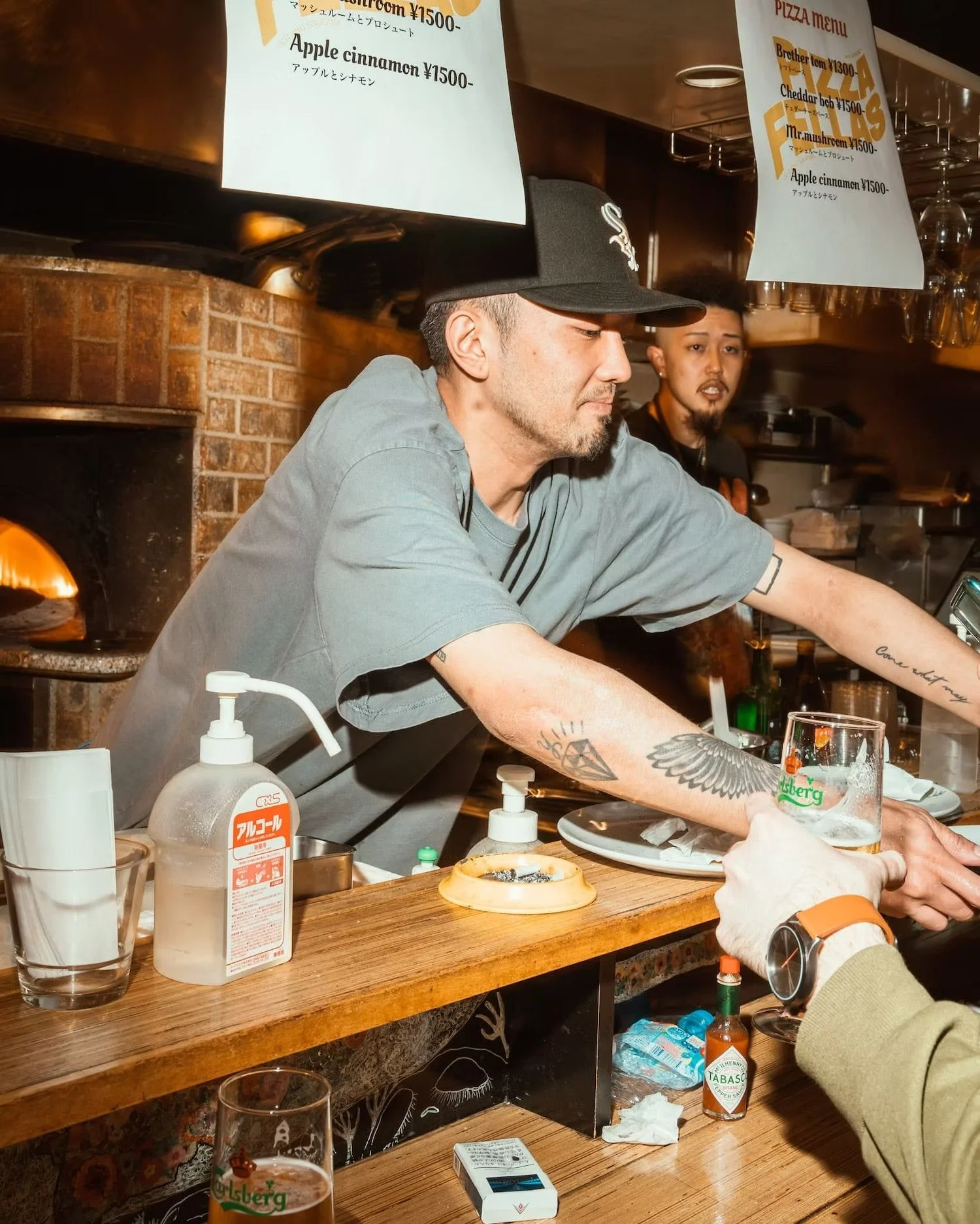 Serving drinks at the pizza bar with a view
of the pizza oven in the background.