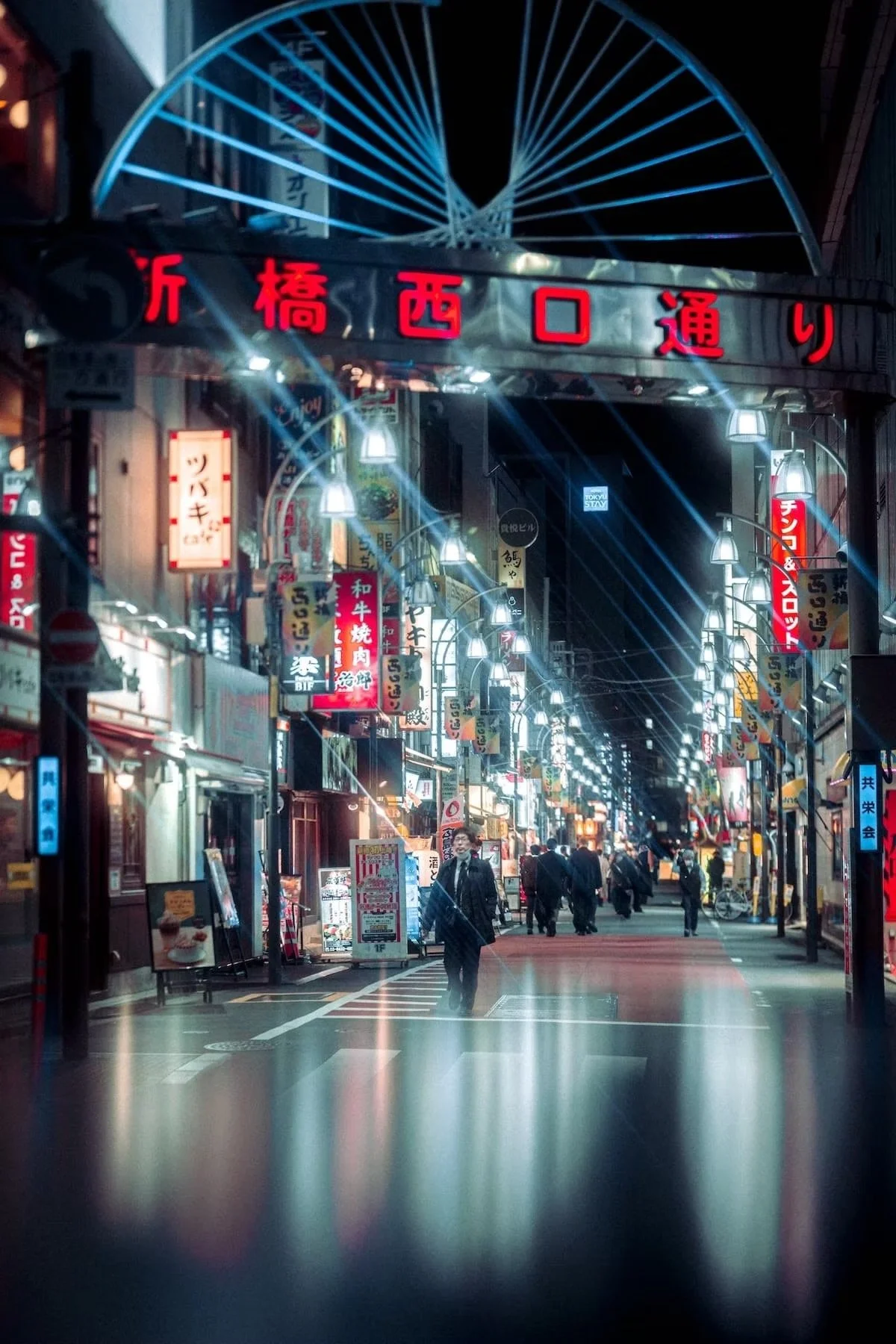 Nighttime street scene in Japan with illuminated signs, people walking looking like a cyberpunk scene in Shimbashi at night in Tokyo.