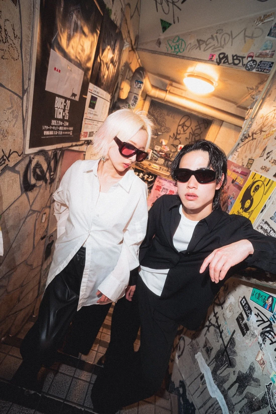 Vasuma Eyewear
---
Two young people, a woman with platinum blonde hair and a man with black hair, wearing sunglasses, pose in a graffiti-covered alleyway. Fashion shoot for brand Vasuma Eyewear.