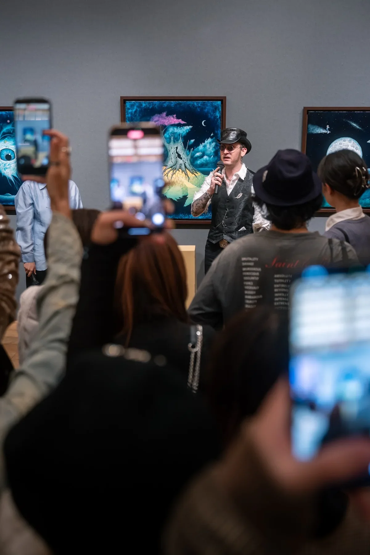 August Vilella
---
Visitors photograph a presentation during August Vilella's exhibition, capturing the artist's colourful surrealist paintings and the lively atmosphere of a contemporary art gallery event in Ginza, Tokyo.