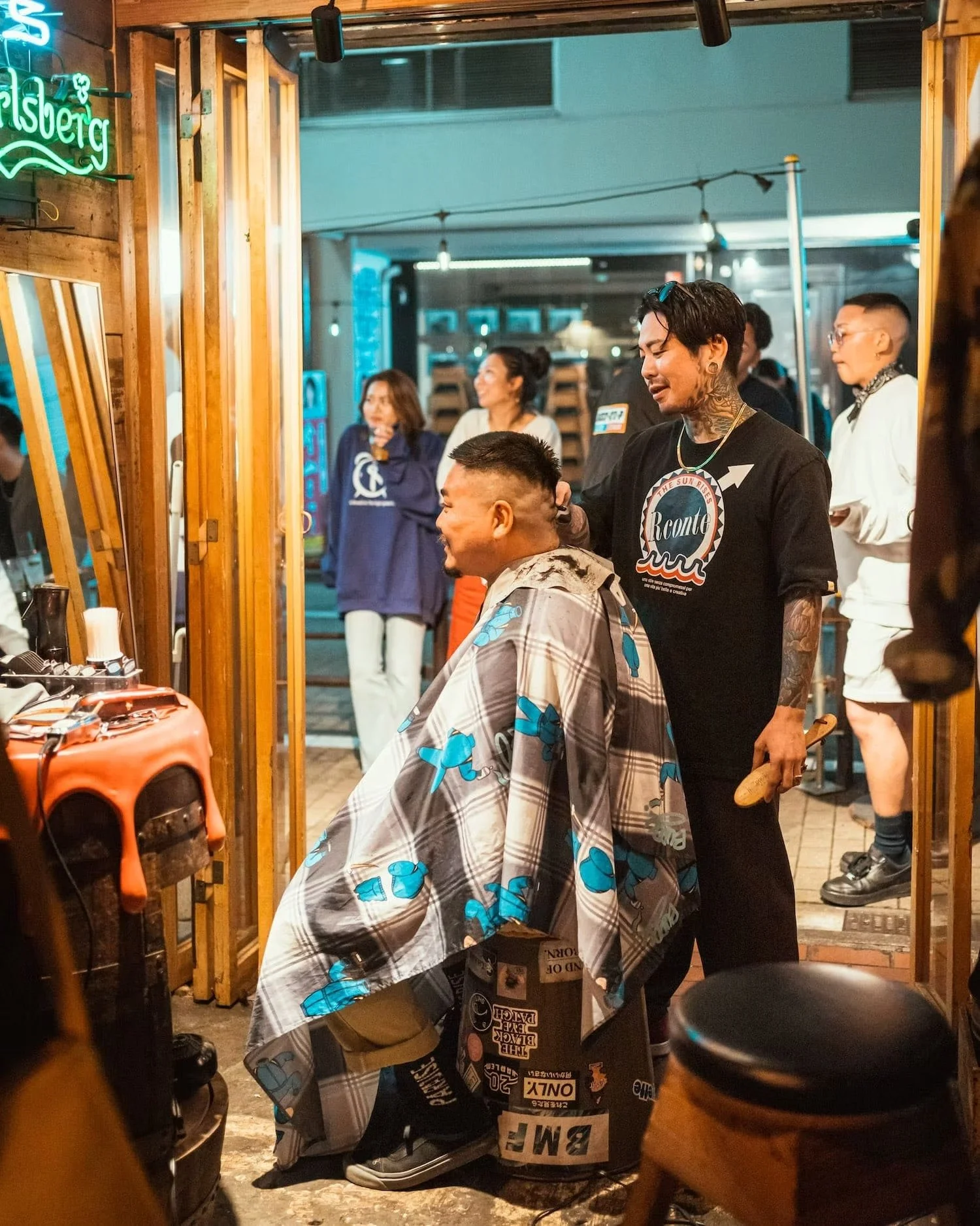 Hair cut session at an outdoor barbershop in Shibuya at night