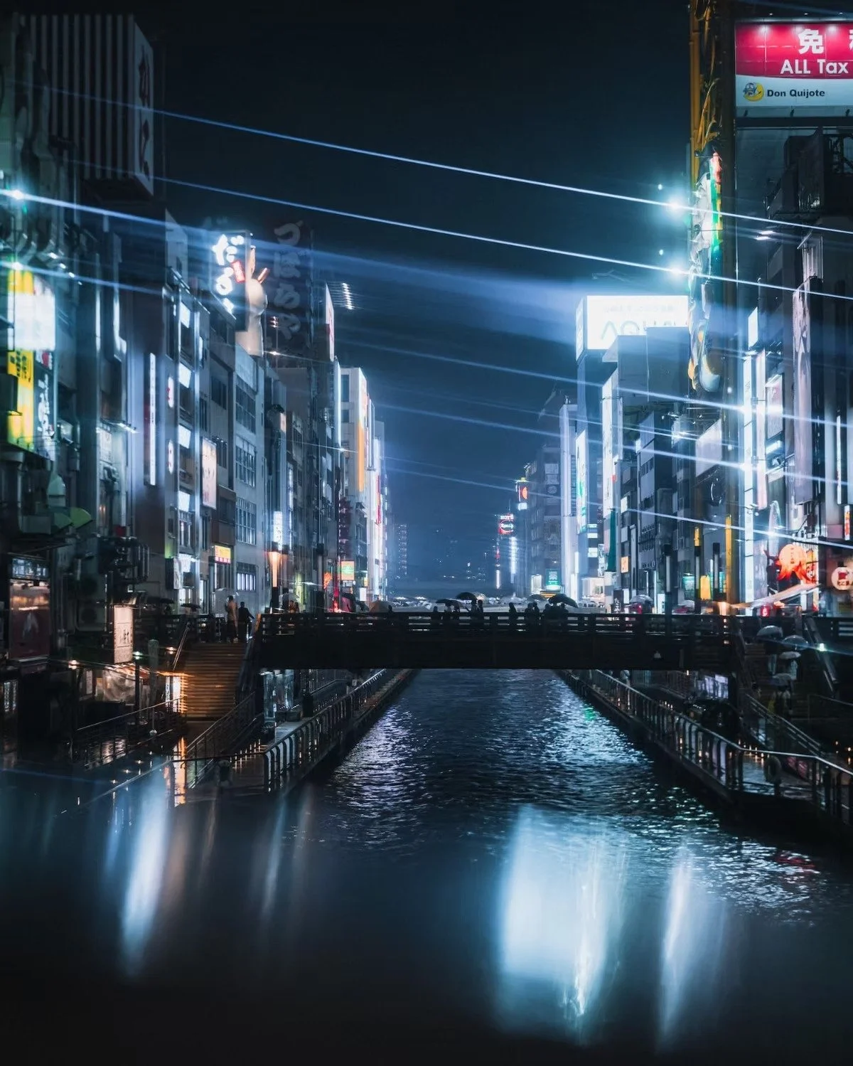 A cyberpunk nighttime cityscape of Osaka Tokyo, Japan, with illuminated billboards and neon signs along a canal with a bridge in the foreground. The street is bustling with lights reflecting on the water.
