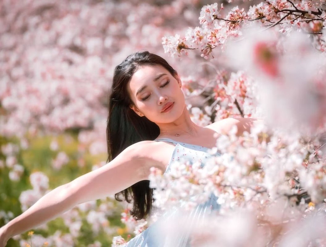 Japanese model enveloped in spring cherry blossom sakura flowers giving a sense of freedom photographed by Deniz Demir