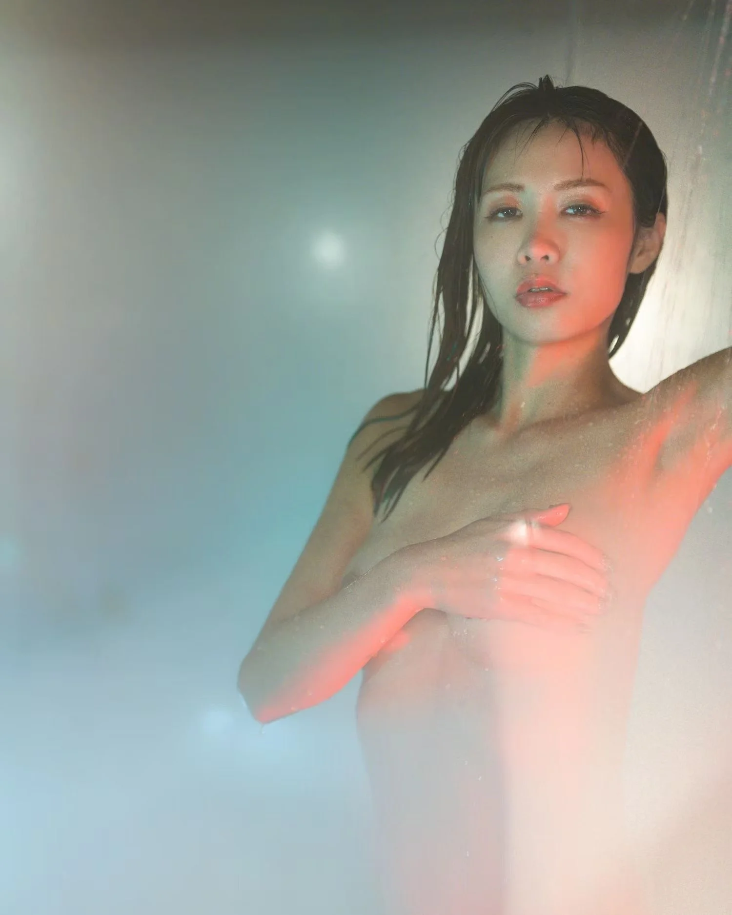 A woman with wet hair partially covering her face, looking directly at the camera, with her hand covering her chest, in a minimalistic and artistic style.