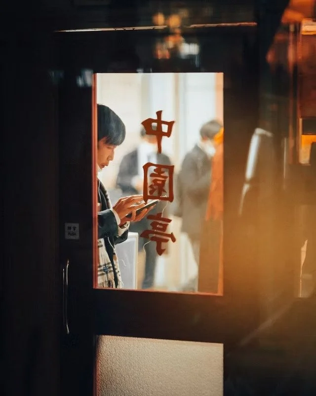 Man on Phone Behind Restaurant Window
