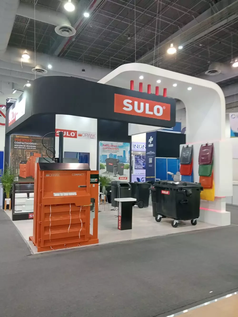 Área de exhibición de equipo pesado con organización estratégica para flujo de visitantes.