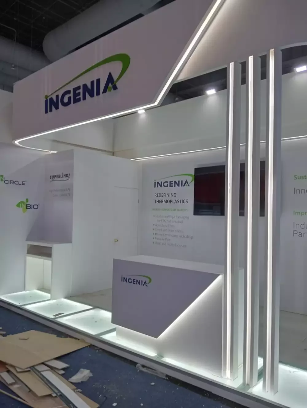 Stand conceptual "Redefining Thermoplastics" con nichos iluminados para muestras de producto.