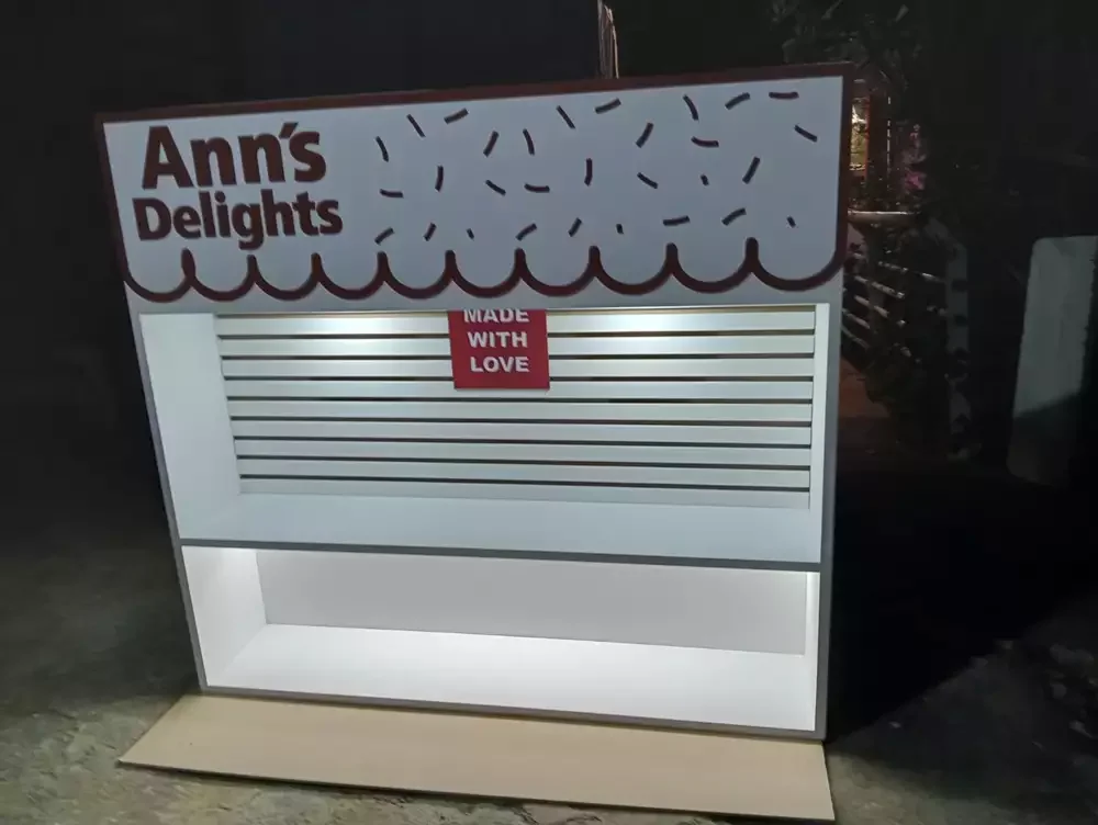 Display comercial en blanco y rojo con acabados de carpintería detallada para puntos de venta.