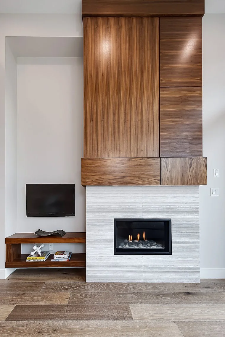 Modern living room with a built-in fireplace, mounted flat-screen TV, and wooden wall paneling