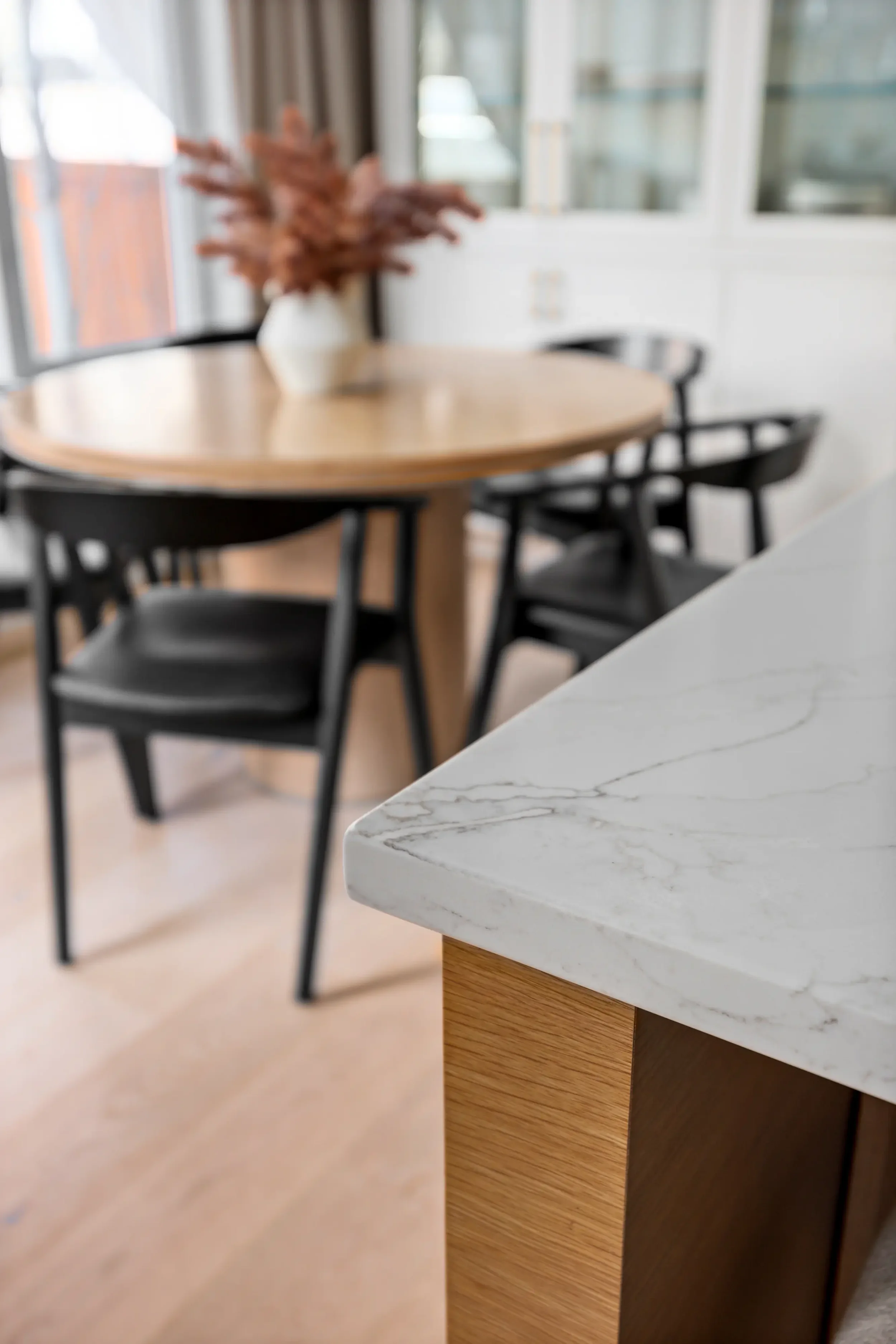 Close-up of kitchen countertops with different materials, including marble, wood, and dark wood, arranged in a row.