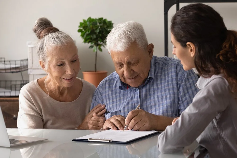 jul-2024-capsule2-older-adult-signing-paperwork-with-family.jpg