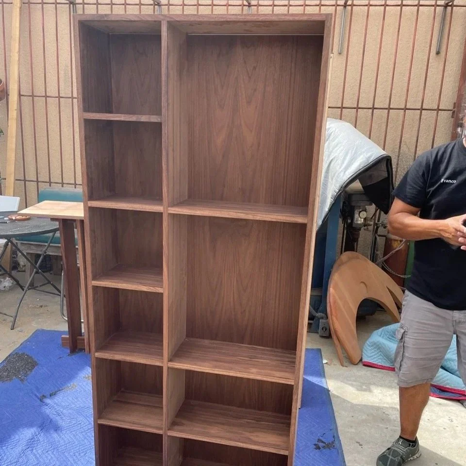 Empty wooden bookshelf with five shelves standing in woodworking studio.