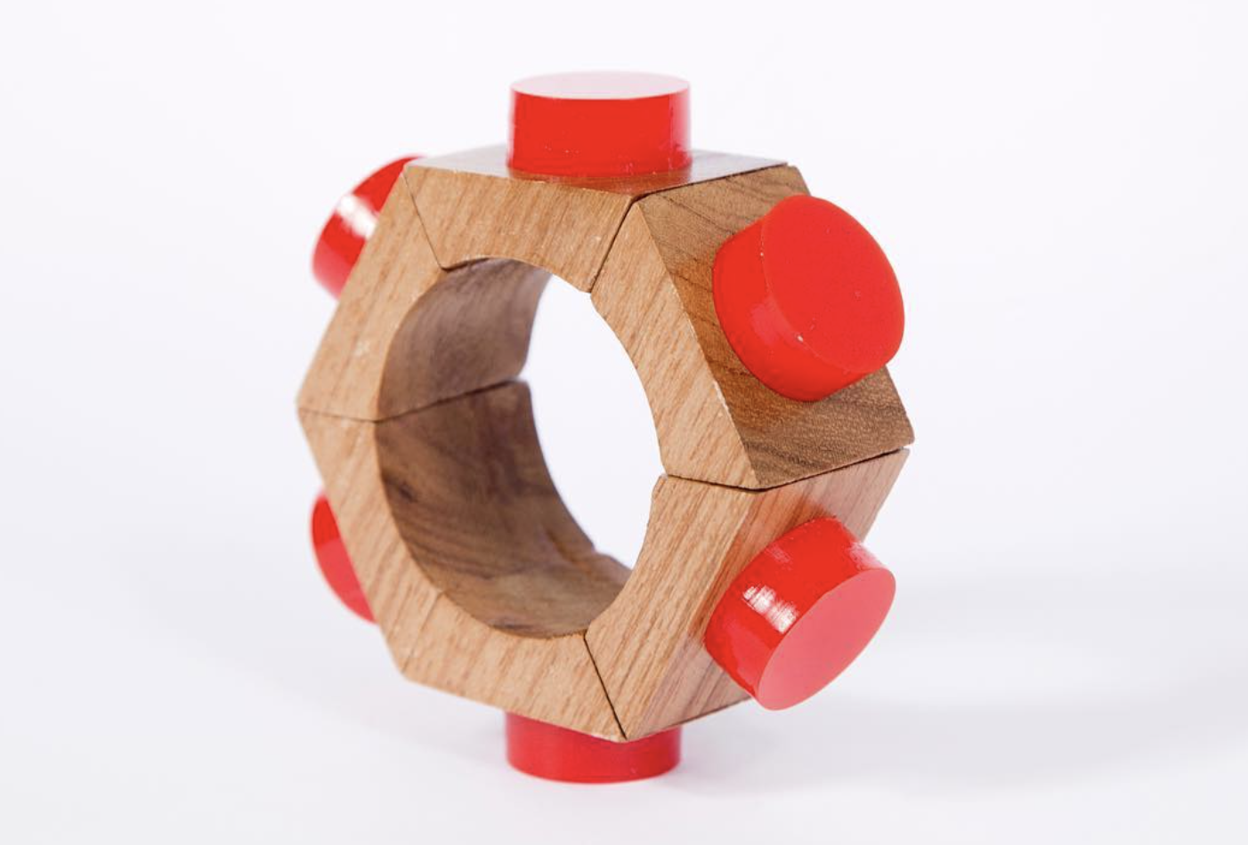A wooden ring with red circular rubber accents on a white background.