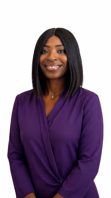 A woman with shoulder-length black hair, wearing a purple top and a necklace, smiling at the camera against a plain white background.