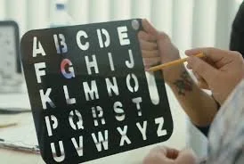 A person holding a black stencil letterboard inside an office.