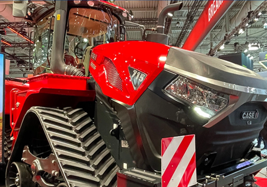 Close-up of a red and black CASE IH tractor displayed at an indoor exhibition.