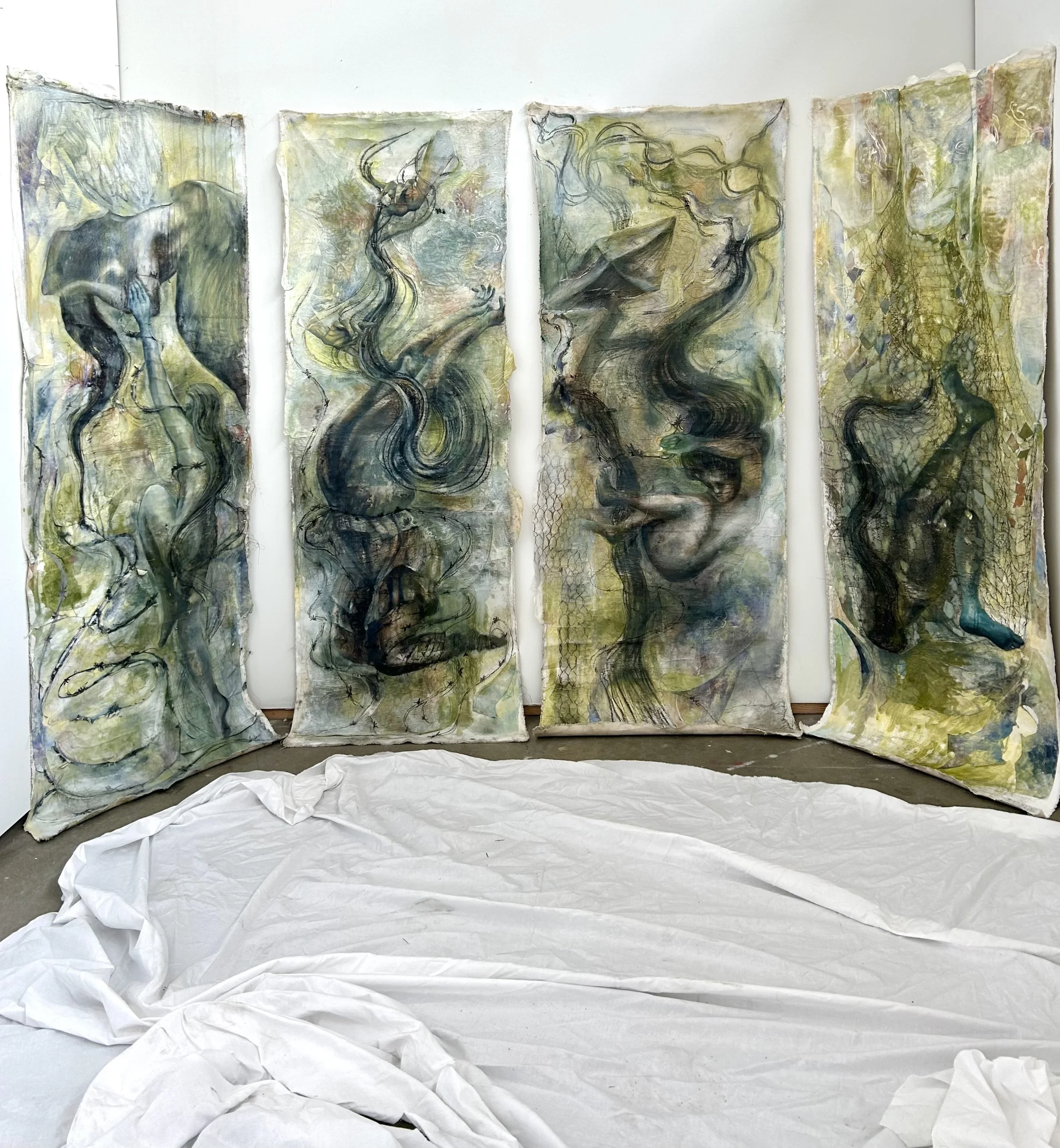 Abstract mixed media artwork consisting of five large, vertically oriented panels with swirling, dynamic lines and organic shapes in shades of green, yellow, gray, and black, displayed in a gallery space with a draped white sheet on the floor.