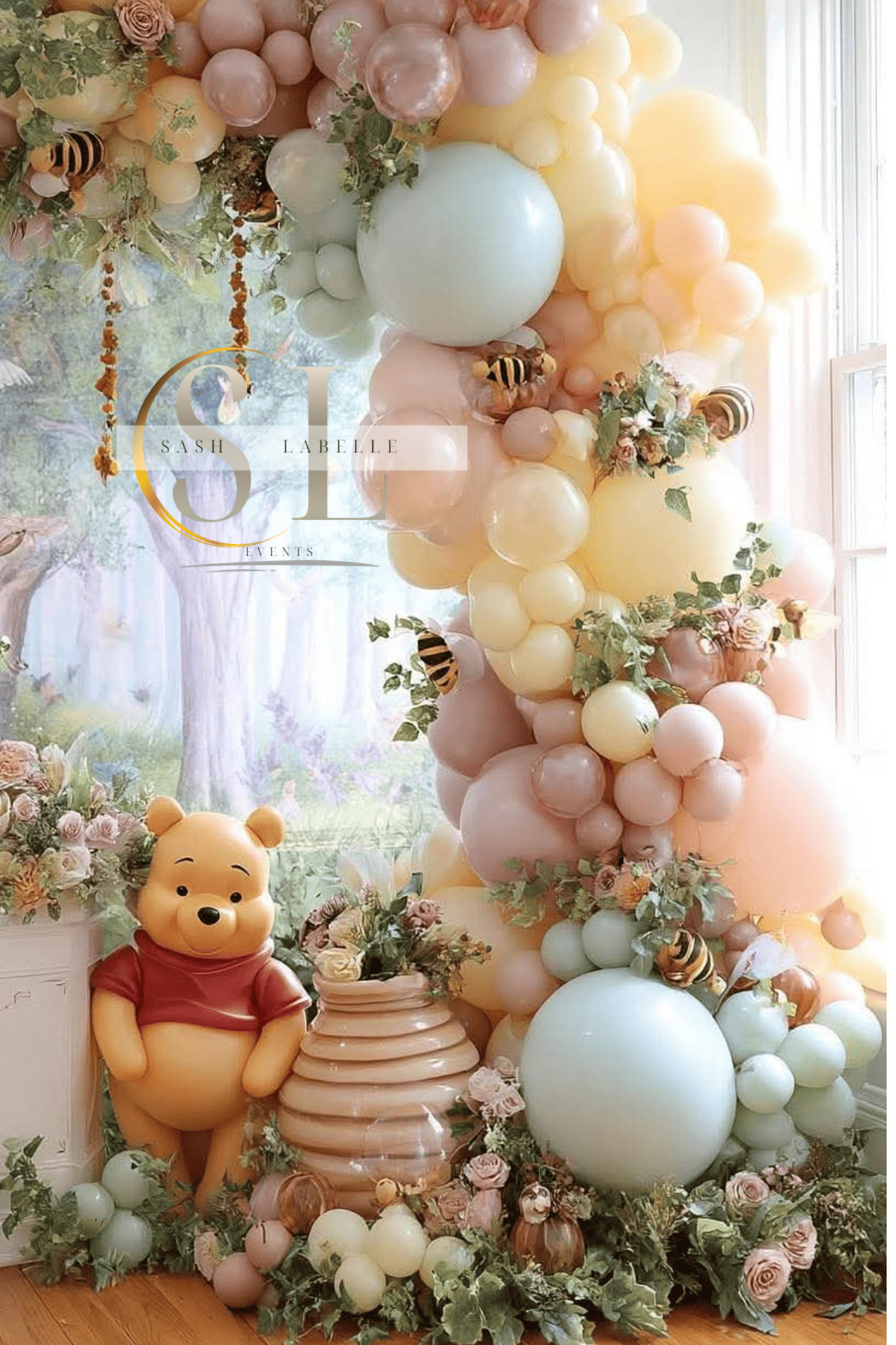 Decorative display with pastel-colored balloons, flowers, a Winnie the Pooh plush toy, and bees for a celebration or event.