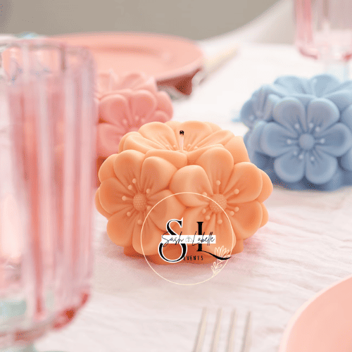 Decorative pastel-colored candles shaped like flowers on a table setting.
