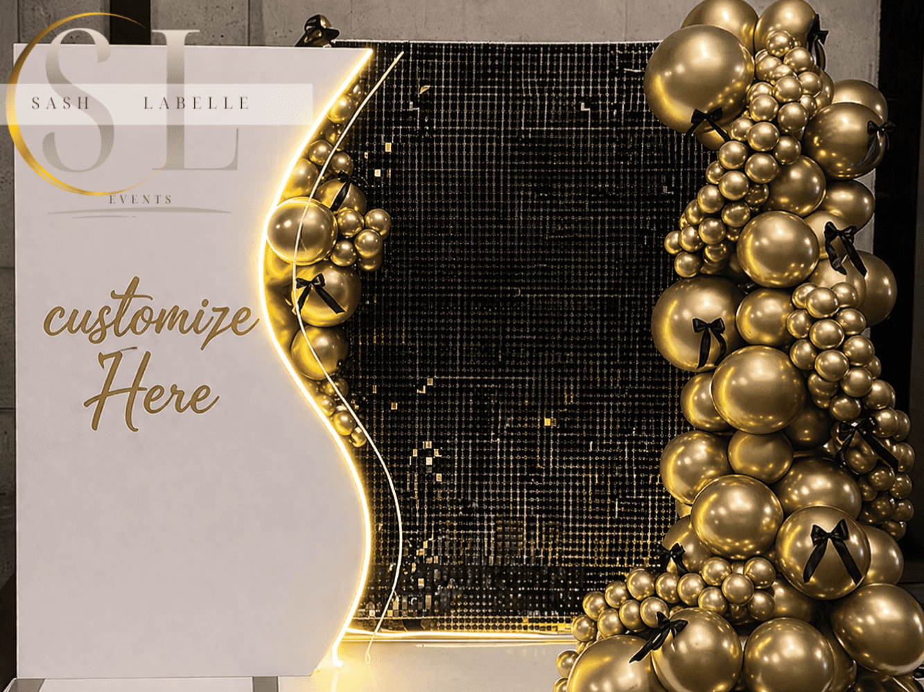 Elegant event backdrop with gold balloons, black ribbons, and a white sign reading "customize Here" for Sash Labelle Events.
