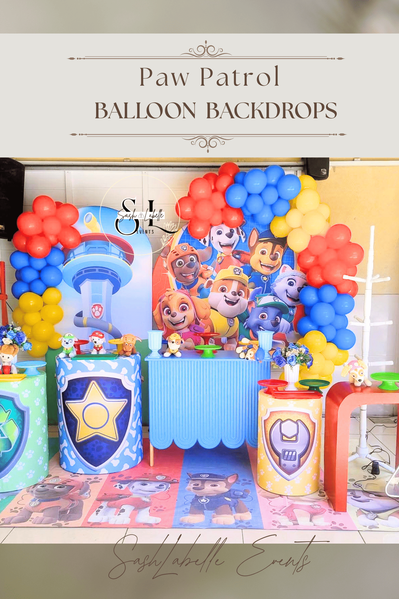 Colorful Paw Patrol themed birthday party backdrop with balloon arch, character cutouts, themed tables, and floor decals.