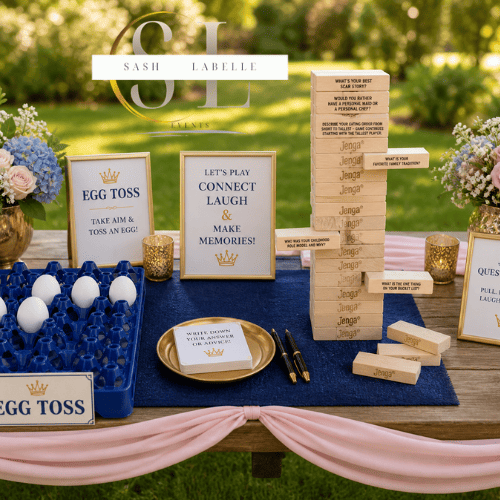 Wedding game station with signs, eggs for a game, Jenga, and decor on a wooden table outdoors with greenery in the background.