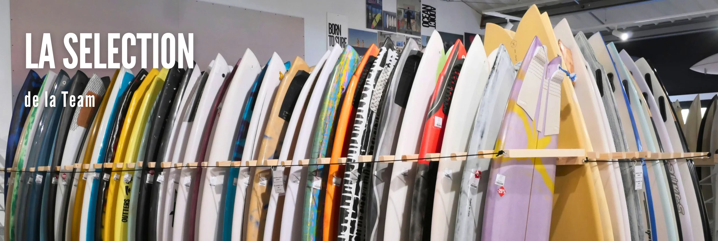 Planche de surf colorée alignée en rayon dans un magasin.