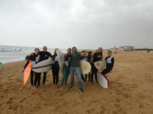 Groupe de personnes avec des planches de surf sur une plage. 