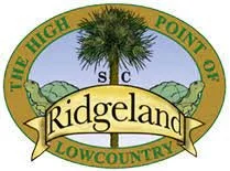 A circular logo with a palm tree in the center. It has the text 'The High Point of Ridgeland' and 'Lowcountry' surrounding the image.