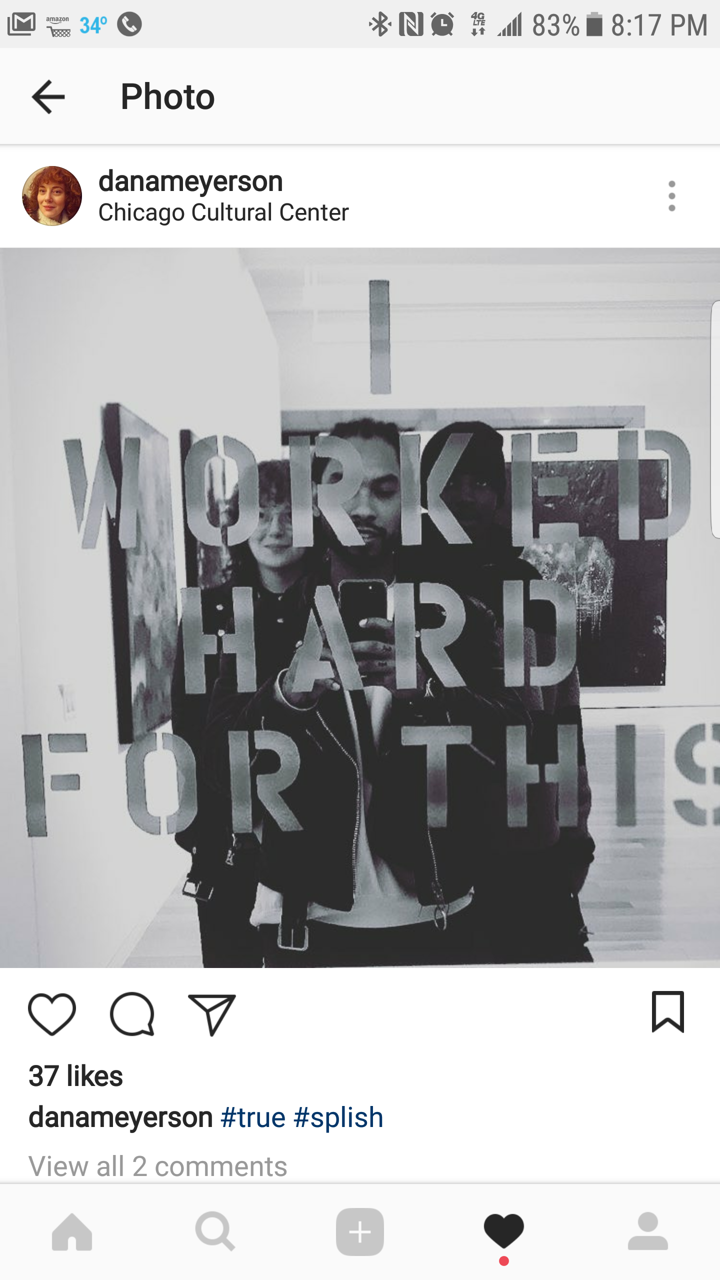 Mirror with the words 'WORKED HARD FOR THIS' cut out, reflecting three young men taking a selfie at the Chicago Cultural Center.